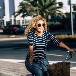 a woman riding a bicycle through a neighborhood