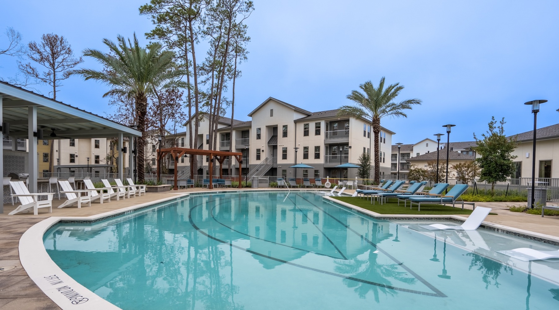 a pool with lounge chairs around it and a building in the background