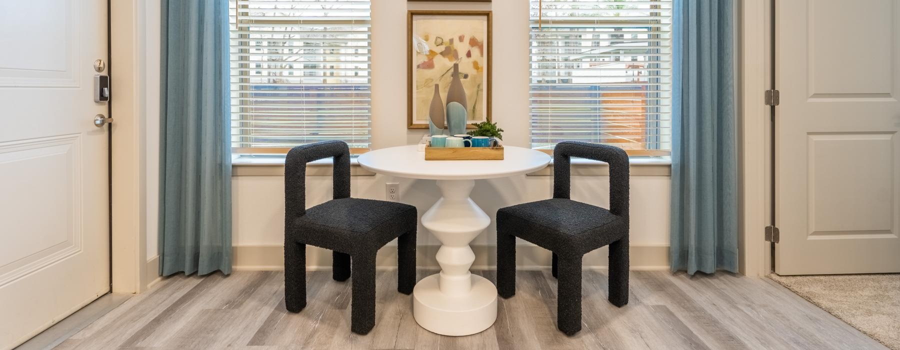 table and chairs next to windows